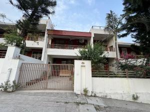 リシケーシュにあるLuxury Villa Rishikeshの門と柵のある白い家