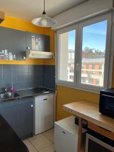 a small kitchen with a sink and a window at Beau studio avec vue sur Paris in Meudon