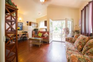 a living room with a couch and a kitchen at The Dolphin Cottage at Kehena Beach in Kehena