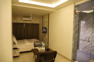 a bedroom with a bed and a desk with a chair at Hotel PNP Royal in Amarnāth