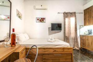Cette chambre comprend un lit, un bureau et une télévision. dans l'établissement Super Cozy Apt near City & Beach, à Thérissos