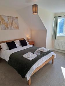 a bedroom with a large bed with two towels on it at Rural retreat in Longframlington