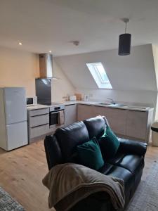 a living room with a black leather couch in a kitchen at Rural retreat in Longframlington