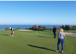 een groep mensen die golfen op een golfbaan bij Charmant Gîte à St-Cast in Saint-Cast-le-Guildo