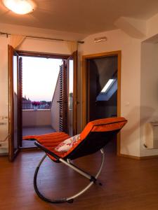 een oranje en zwarte stoel in een kamer met een raam bij Apartments Anuška in Cavtat