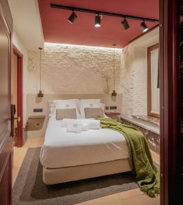 a bedroom with a large white bed with red walls at LIRIUM Casa Patio in Seville