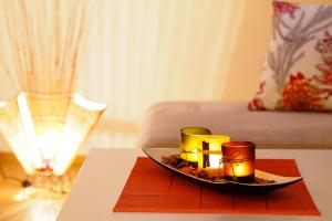 een dienblad met kaarsen op een tafel met een bed bij Apartments Anuška in Cavtat