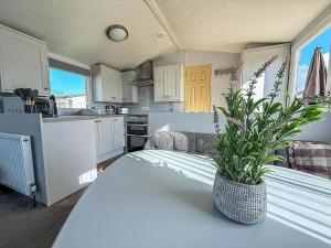 - une cuisine avec une table et une plante en pot dans l'établissement Beautiful Caravan At Manor Park Holiday Park In Hunstanton Ref 23060W, à Hunstanton
