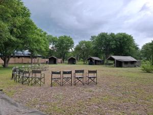 马翁Se xaxa Camp的一组桌椅,位于一个有帐篷的场地