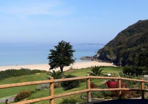 een uitzicht op een strand met een houten hek bij Charmant Gîte à St-Cast in Saint-Cast-le-Guildo