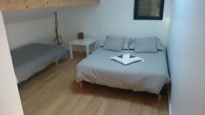 Un dormitorio con una cama y una mesa con un cuenco encima. en Maison avec 3 appartements à 5min de la plage sud, en Lacanau