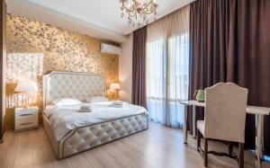 a bedroom with a bed and a table and a chair at Rivendell Boutique By Umbrella in Tbilisi City