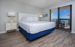 una camera da letto con un letto grande e un balcone di Phoenix VI 6803 condo a Orange Beach