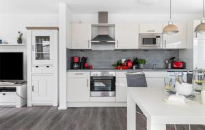 een keuken met witte kasten en een wit aanrecht bij Sutsche in Olpenitz