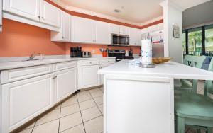 eine Küche mit weißen Schränken und einer Arbeitsplatte in der Unterkunft Phoenix on the Bay 1121 condo in Orange Beach