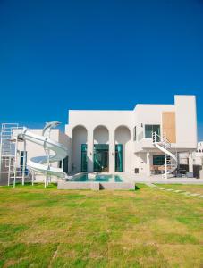 a white house with a swimming pool and a slide at The Woofington Pet Friendly Pool Villa in Ban Bo Prakhon