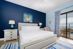 a bedroom with a white bed and a blue wall at Phoenix V 105 condo in Orange Beach +46 photos