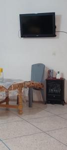 una mesa y una silla con TV en la pared en CasAmer, en Temara