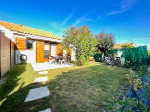a small yard with a house with a yard at Charmante Maison proche mer avec piscine collective in Brem-Sur-Mer