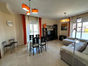 ein Wohnzimmer mit einer Couch und einem Tisch und Stühlen in der Unterkunft Piso en Linares zona Paseo con parking gratis in Linares