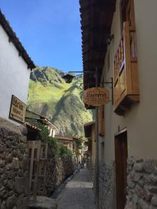 a narrow alley with a mountain in the background at Kamma Guest House in Ollantaytambo