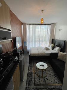 a small room with a bed and a couch at Bliss Apartment Tsavo Fedha near JKIA in Nairobi