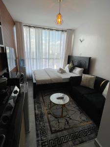 a living room with a bed and a couch at Bliss Apartment Tsavo Fedha near JKIA in Nairobi