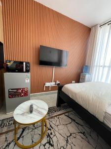a hotel room with a bed and a table and a tv at Bliss Apartment Tsavo Fedha near JKIA in Nairobi