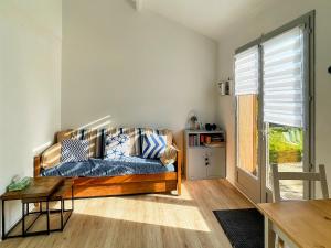 a living room with a couch and a table at Charmante Maison proche mer avec piscine collective in Brem-Sur-Mer