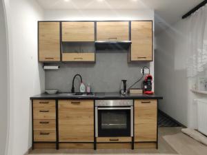 a kitchen with wooden cabinets and a stove at Apartament Na Uboczu in Pszenno