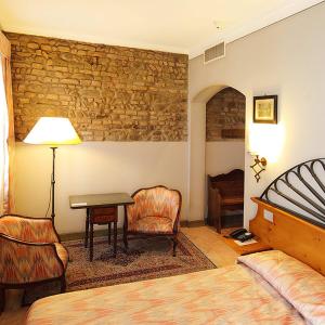 a bedroom with a bed and a table and chair at Hotel Arnaldo Aquila D’oro in Rubiera