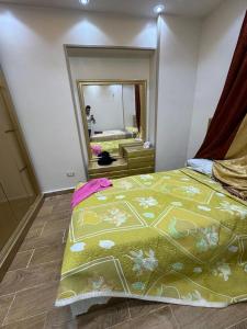 a bedroom with a bed and a large mirror at المنصوره الجديده جنه 2 شقه فيو فيلل وجاردن in Zayyān