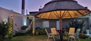 eine Terrasse mit einer Hängematte und einem Sonnenschirm in der Unterkunft El jacaranda Alojamiento Diario in San Luis