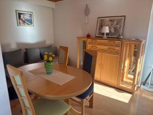 a dining room table with a vase of flowers on it at Gemütliche Ferienwohnung nähe Schloss Benrath & Rhein Düsseldorf Urdenbach in Düsseldorf
