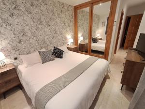 a bedroom with a large white bed and a mirror at Desert Springs award-winning Golf Resort apartment in La Hoya del Camaino +26 photos