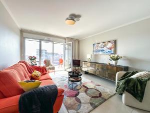a living room with a red couch and a tv at Appartement Alchimy in Antibes