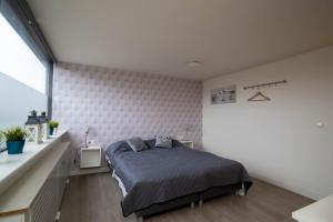 a bedroom with a bed and a white wall at Luxury apartment in the center in Medemblik