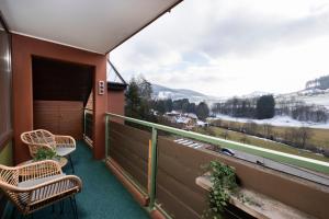a balcony with two chairs and a view of the mountains at Ferienwohnung Wipfelglück in Baiersbronn