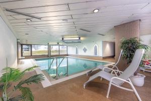 a pool in a building with a chair at Ferienwohnung Wipfelglück in Baiersbronn