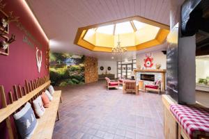 a living room with a fireplace and red chairs at Ferienwohnung Wipfelglück in Baiersbronn