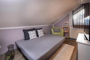 a bedroom with a bed and a green chair at Ferienwohnung Wipfelglück in Baiersbronn +19 photos