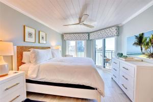 a white bedroom with a bed and a window at Land's End 5-203 Gulf-Bay Front - Premier in St Pete Beach +56 photos