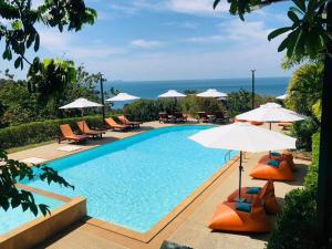 a swimming pool with chairs and umbrellas at Bakantiang Resort in Ko Lanta
