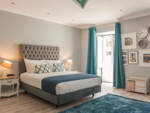 a bedroom with a large bed with blue curtains at Vila Garden Guesthouse in Lisbon