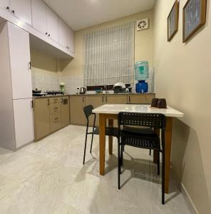迪布鲁加尔Dibru Ghar Homestay的房间里有一张桌子和几把椅子的厨房 更多3张照片