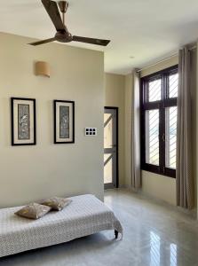 迪布鲁加尔Dibru Ghar Homestay的带床和吊扇的卧室