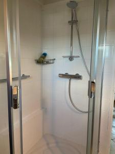 a bathroom with a shower with a glass door at Appartement Ô Nid Perché Vue mer in Agon Coutainville