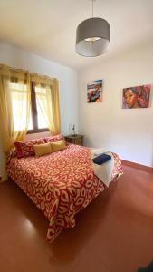 a bedroom with a bed with a red and white blanket at Cortijo Batán in Dúdar