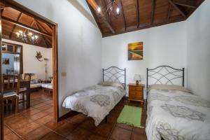 sypialnia z dwoma łóżkami i jadalnią w obiekcie CASA CRUZ EL LLANO w mieście El Pinar