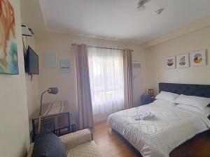 a small bedroom with a bed and a window at Chic and Affordable Studio in Davao City